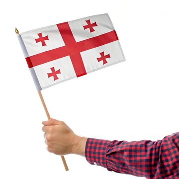 A realistic digital illustration of a hand holding a small Georgian flag on a wooden stick. The flag features a white background with a bold red cross in the center and four smaller red crosses in eac