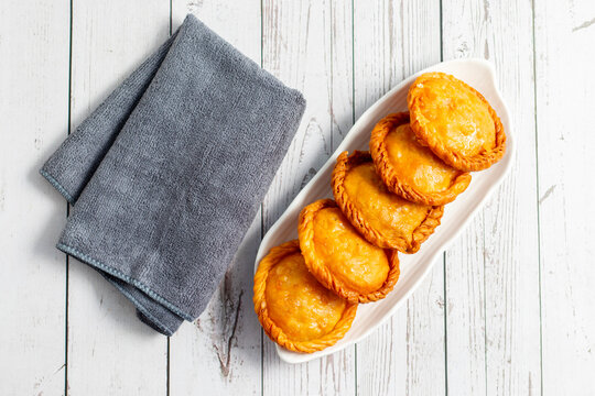 Chandrakala is a traditional Indian sweet, similar to gujiya, with a crispy outer shell and a rich stuffing of khoya, nuts, and sugar, deep-fried and dipped in sugar syrup.