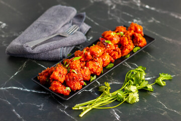 Gobi Manchurian is a crispy, spicy Indo-Chinese dish made with battered, fried cauliflower tossed in a tangy, flavorful soy-garlic sauce.