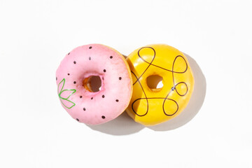 Two decorated donuts on a white background. 