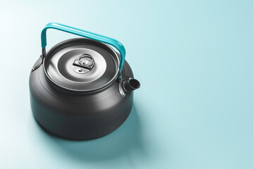 Metal kettle on blue background.