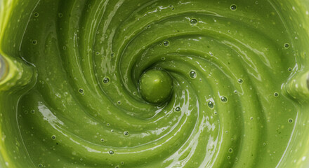 Top view of a blender filled with freshly blended green smoothie.