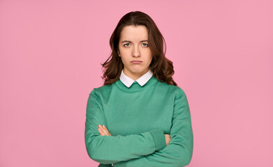 Portrait of a sympathetically unhappy and grsty young woman in a green sweater isolated on a pink background. Emotions - bad mood, failures, problems.