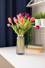 Morning spring still life with bouquet of fresh tulips on table. Interior design. vertical.