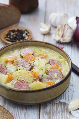 A bowl with traditional German potato soup with sausages
