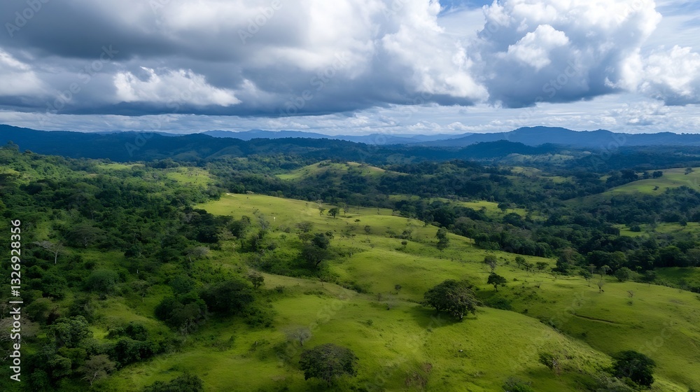 Poster expansive aerial view of lush green hills and valleys under a dramatic sky with fluffy clouds above 