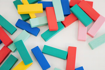 Colorful building blocks scattered on a white surface inviting creativity
