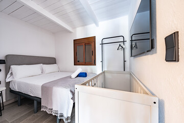 an image of a small bedroom with baby cot in holiday home 