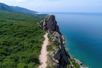 A breathtaking view of a coastal cliff with lush greenery and a clear blue ocean, inviting adventure and tranquility while showcasing the beauty of nature.
