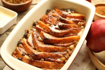 Freshly baked bread pudding in baking dish on table, closeup