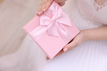 Bride with beautiful wedding gift indoors, closeup