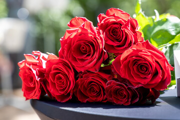 A bouquet of fresh red roses on a table. Romantic floral arrangement perfect for Valentine's Day, weddings, love, and celebration themes.