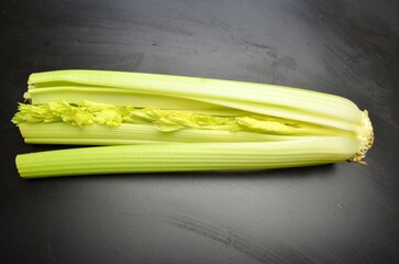 green celery leaves celery stalk close up on black background