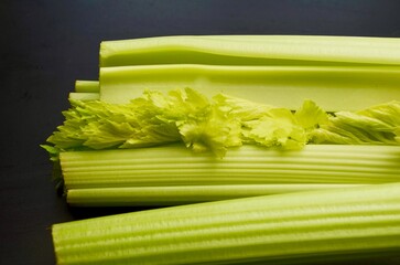 green celery leaves celery stalk close up on black background
