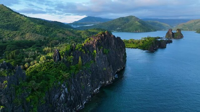 Aerial view of a beautiful pinnacle surrounded by a serene ocean and lush green reef, Pindache, North Providence, New Caledonia.