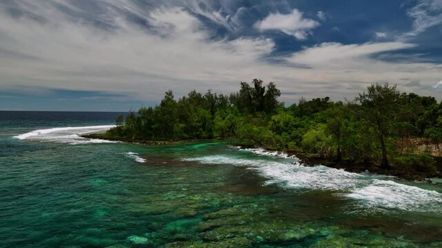 Aerial view of beautiful tropical beach with coral reef, waves, and lush palms, Port Vila, Shefa, Vanuatu.