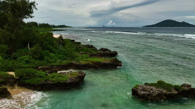 Aerial view of beautiful tropical beach with pristine shoreline, azure waves, and lush palms, Port Vila, Shefa, Vanuatu.