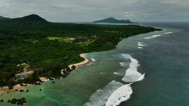 Aerial view of beautiful beach with palm trees and clear water over a vibrant reef, Port Vila, Shefa, Vanuatu.