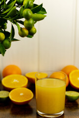 Sliced oranges, a close-up glass of freshly squeezed orange juice. Fresh juice