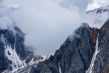 Daytime photo of a mountain and mountain range with glaciers and cliffs. 