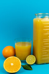 Orange pillows, a glass of orange juice on a blue background. Oranges and juice