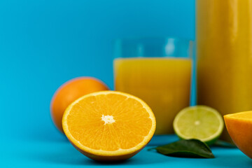 Orange pillows, a glass of orange juice on a blue background. Oranges and juice