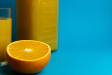 Close-up of freshly cut orange and glass of freshly squeezed juice