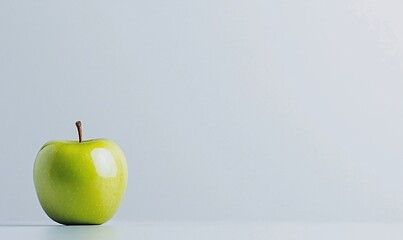 Single green apple on a minimalist gray background.