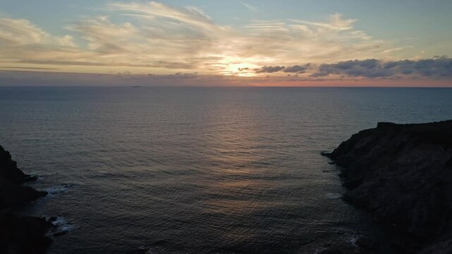 Aerial view of Cala della Signora with calm sea at sunset under a blue sky, Sant'Antioco, Sardinia, Italy.