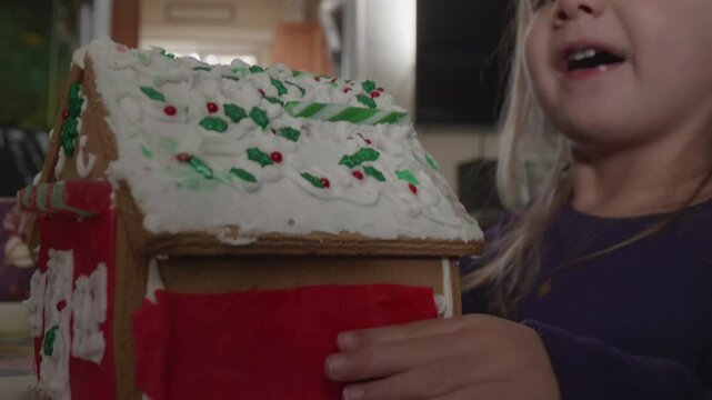 Cute Toddler Girl Trying to Eat Gingerbread House