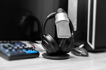 A professional condenser microphone on a desktop stand is set up in a modern gaming and recording...