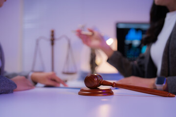 Two lawyers engaging in a discussion about legal issues within a law office, featuring a gavel and...
