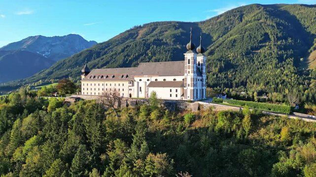 Aerial view of a picturesque abbey and monastery surrounded by a serene mountain landscape in autumn, Frauenberg an der Enns, Styria, Austria.