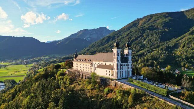 Aerial view of a picturesque abbey and monastery surrounded by a serene mountain landscape in autumn, Frauenberg an der Enns, Styria, Austria.