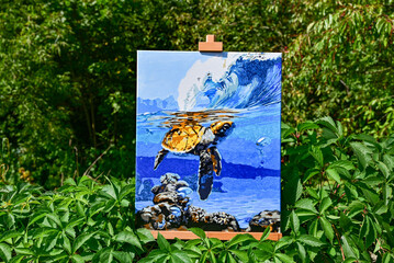 A vibrant painting displayed outdoors, placed on an easel amidst a beautiful natural landscape,...