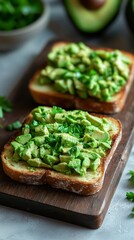 Toasted sandwich generously topped with avocado slices on a wooden board with vibrant green accents for foodies