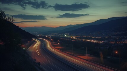 Fototapeta premium A quiet highway at night, illuminated by rows of streetlights, with the soft glow of the lights reflecting on the road and surrounding landscape.