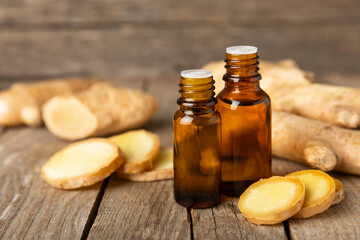 Ginger essential oil on texture background. Fresh ginger slices. Essence, serum, oil. Alternative...