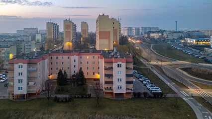 Obraz premium city ​​landscape in poland in the morning. aerial view of sunrise in the city of Kalisz. illuminated apartment blocks, skyscrapers and streets.