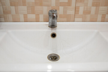  A white sink in the bathroom or toilet with cracks in the form of a spider web.