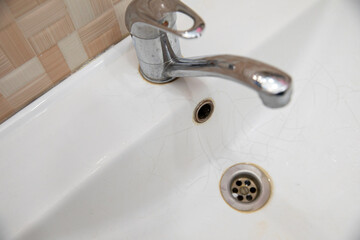 A white sink in the bathroom or toilet with cracks in the form of a spider web.