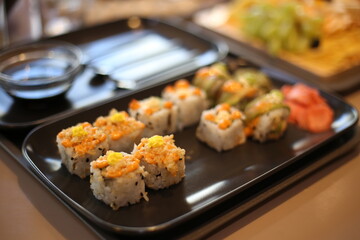 Japanese food sushi on a black plate with soy sauce