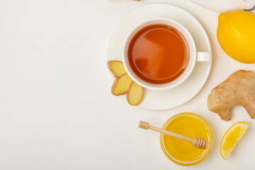 Cup of hot ginger tea with slices of ginger root on wooden background. Warming drink. Alternative medicine. Tea with honey, lemon, ginger and mint. Space for text. Copy space