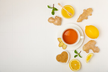 Cup of hot ginger tea with slices of ginger root on wooden background. Warming drink. Alternative medicine. Tea with honey, lemon, ginger and mint. Space for text. Copy space