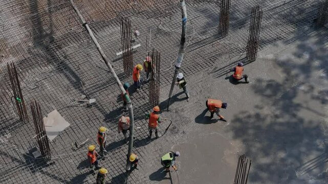 Workers pouring and leveling concrete foundation Aerial view 