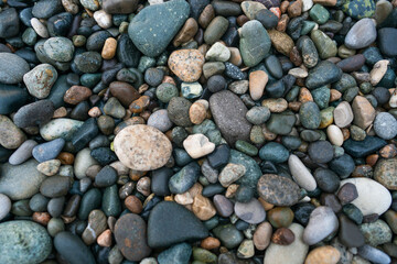 Texture of wet small pebbles of rocks on the beach