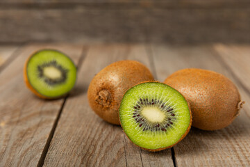Kiwi on wooden background. Whole fruit and slices pieces of green kiwi on table. fresh ripe juicy...
