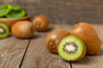 Kiwi on wooden background. Whole fruit and slices pieces of green kiwi on table. fresh ripe juicy...