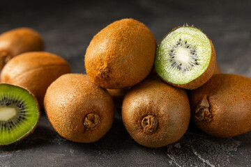Kiwi on wooden background. Whole fruit and slices pieces of green kiwi on table. fresh ripe juicy...