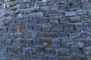 Architectural stone wall with white mortar joints and rugged brown rocks. For the background of your photos and collages